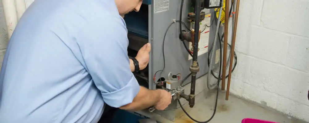 Furnace repair technician inspecting and servicing a home heating system in Colorado Springs, CO