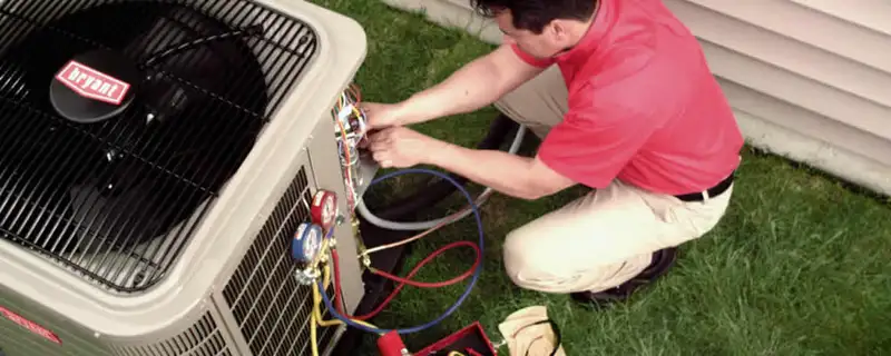 HVAC technician servicing an outdoor air conditioner unit in Colorado Springs, CO