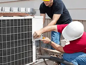 HVAC technicians repairing an outdoor AC unit on a rooftop in Colorado Springs, CO