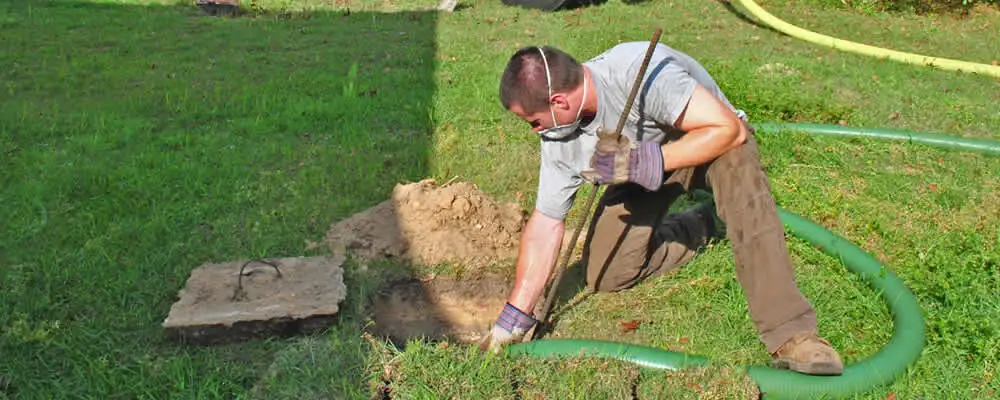 Septic pumping technician servicing a residential septic tank in Colorado Springs, CO