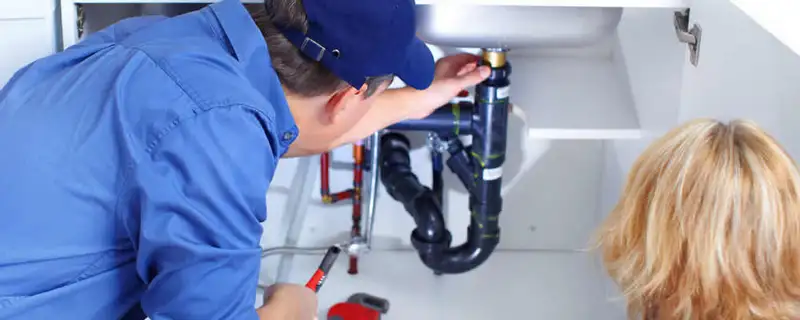 Plumber repairing under-sink drain pipes and fittings in Colorado Springs, CO